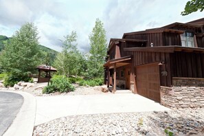 A wooden lodge with a stone foundation, a covered porch, and a stone fireplace. - End Unit Black Bear Townhome - Across from Purg - On Demand Shuttle (Durango)