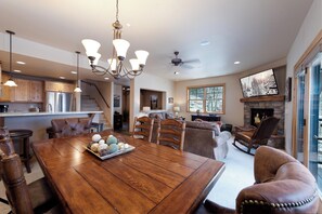A spacious living room with a large wooden dining table, leather sofas, and a fireplace. - End Unit Black Bear Townhome - Across from Purg - On Demand Shuttle (Durango)