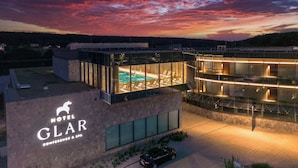 A modern hotel with a glass-enclosed pool and a spa area, surrounded by a scenic landscape. - Hotel GLAR Conference & SPA (gmina Wolin)