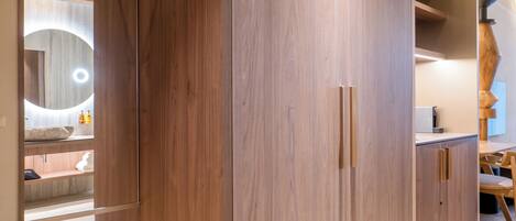 A modern bathroom with wooden cabinetry, a mirror with a circular light, and a wooden vanity.
