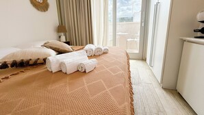 Une chambre d’hôtel avec un lit, des serviettes, une lampe et une vue sur l’extérieur.
