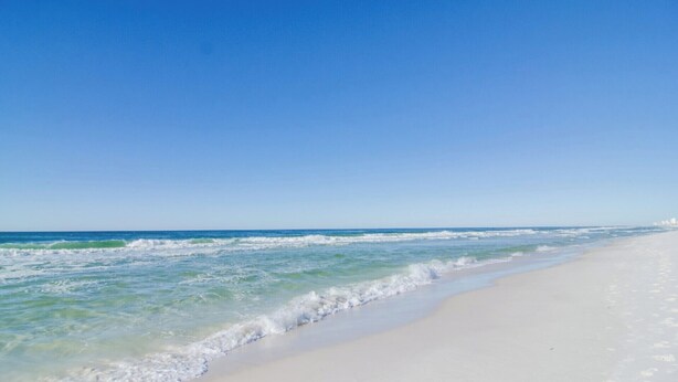 A beach with clear blue water and a sandy shore. - BIG Beachfront Balcony and New Furnishings (Panama City Beach)