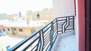 A balcony with a metal railing overlooking a residential area with buildings. - Appartement Meublé à Keur Massar, Dakar Sénégal. Proche Lac Rose et Aéroport (Keur Massar)