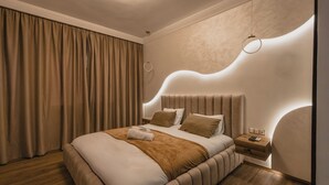 Une chambre moderne avec un grand lit, une table de chevet et un mur aux lignes courbes.