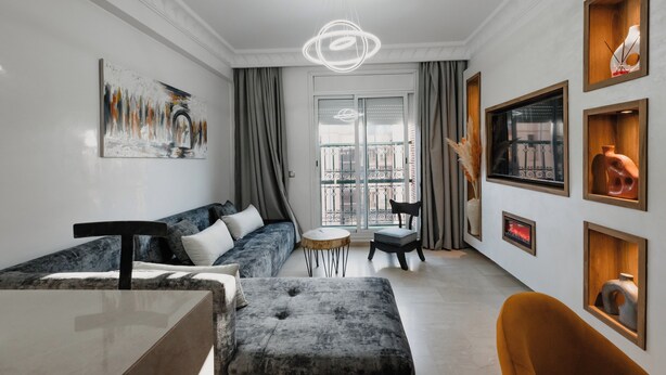 Un salon moderne avec un canapé, un pouf et une table ronde.