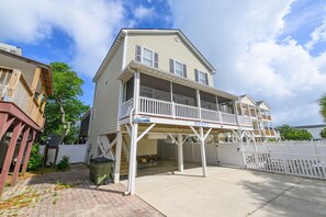 A two-story house with a balcony, a covered porch, and a garage.