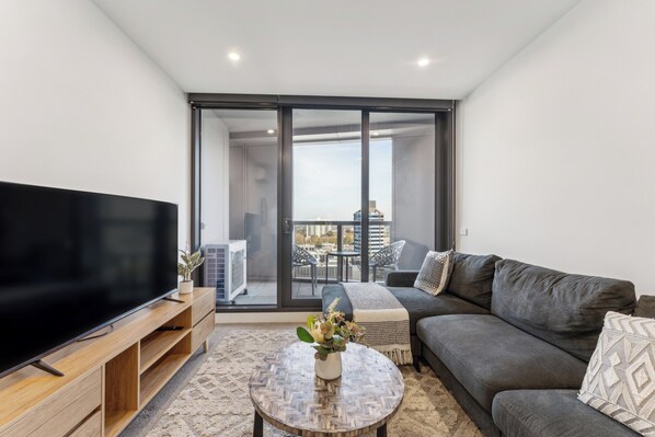 Deluxe Apartment | Living area | 55-inch Smart TV with cable channels - Mega Style Apartments Kings Domain (Southbank)