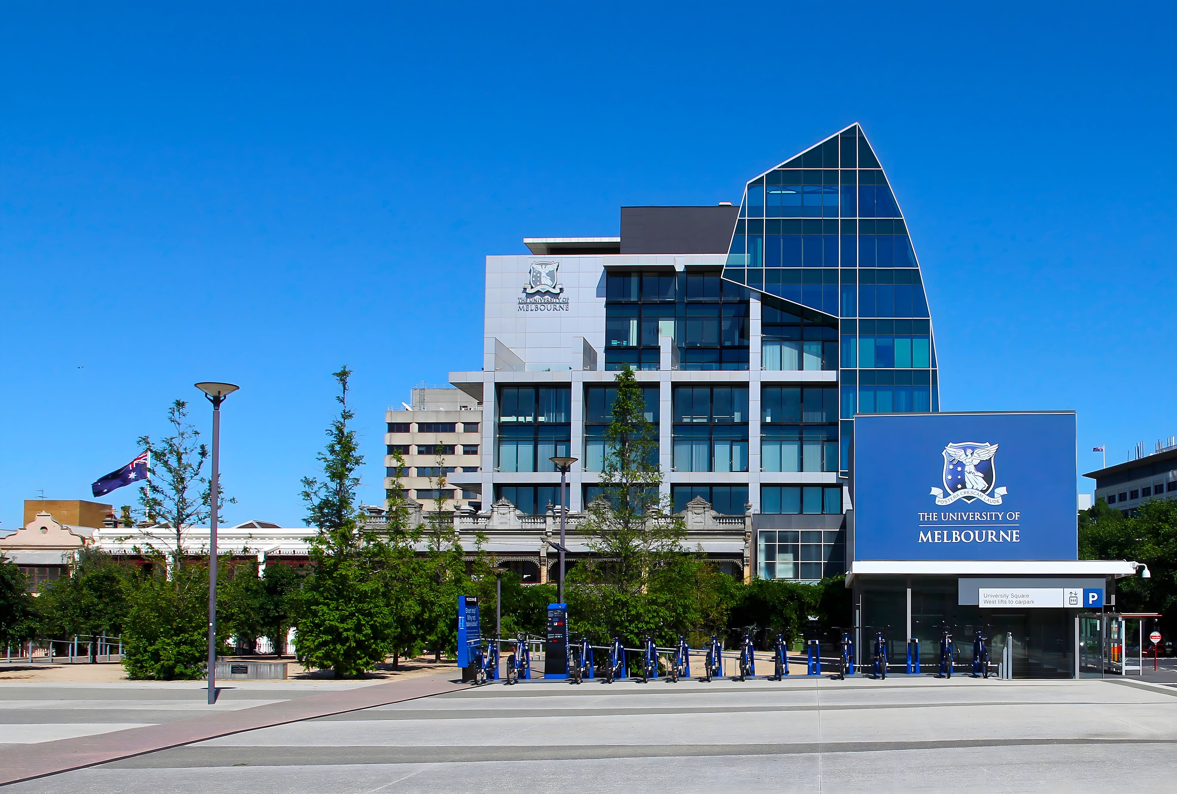 A modern building with a prominent sign for The University of Melbourne.