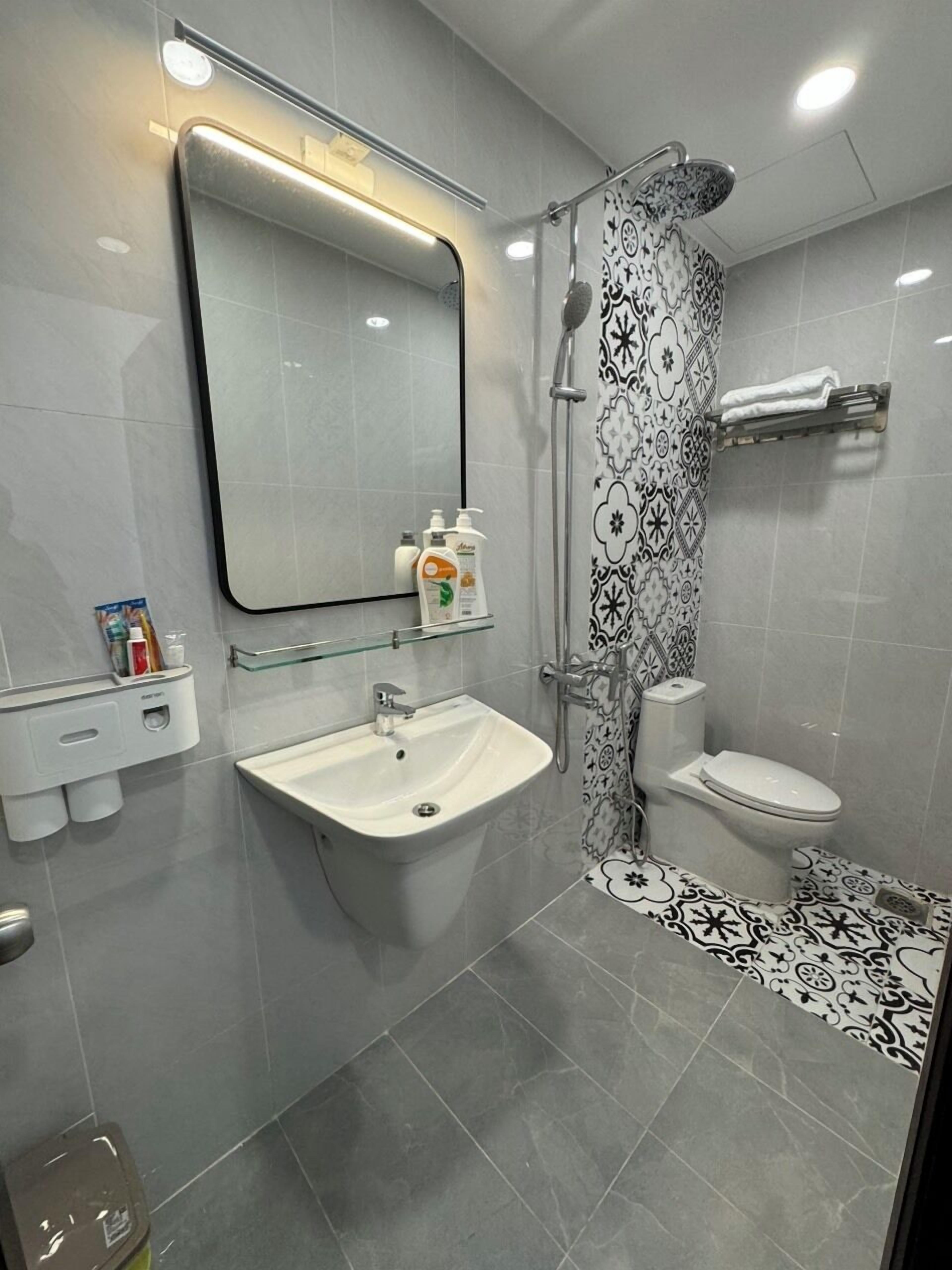 A modern bathroom with a sink, toilet, and shower.