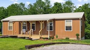 A single-story building with a covered porch, large windows, and a number '107' on the door.