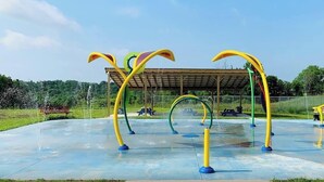 Un patio de juegos exterior con estructuras de escalada coloridas y una zona de estar cubierta.