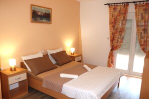 Ein Hotelzimmer mit einem Bett, Nachttischen, einem Bild an der Wand und Vorhängen am Fenster.