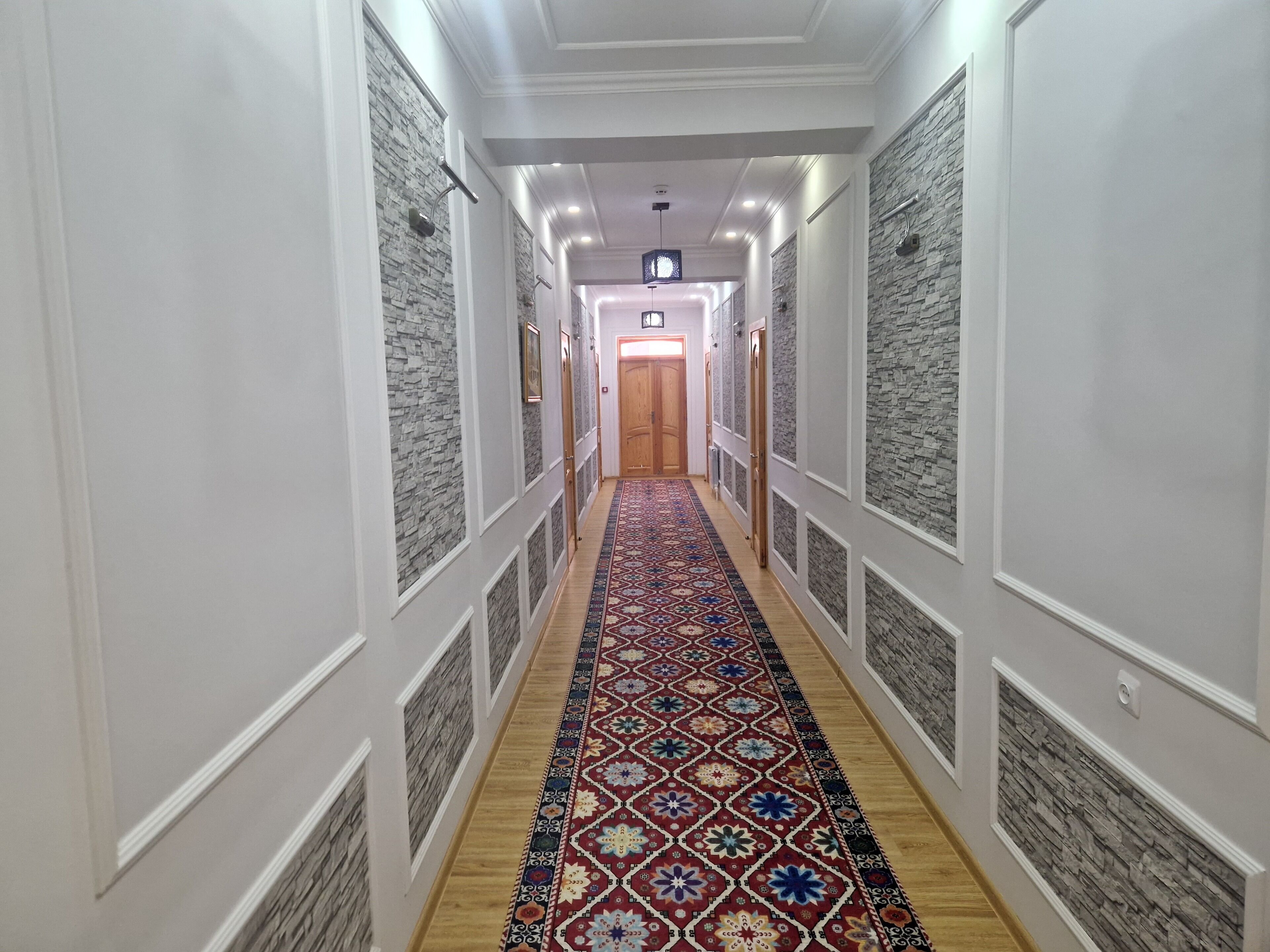 A hallway with patterned walls and a decorative carpet.