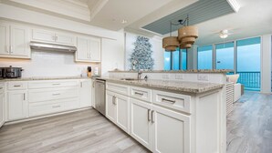 A spacious kitchen with white cabinetry, a granite countertop, and a large island. - Perdido Dunes Tower 9e 4 Bedroom Condo (Orange Beach)