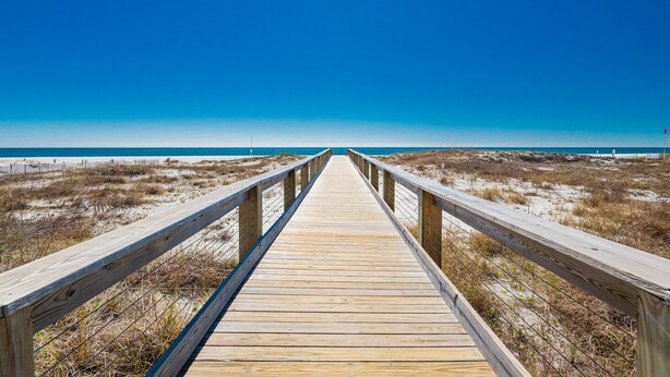 A wooden boardwalk leading to a beach with a clear blue sky. - Perdido Dunes Tower 9e 4 Bedroom Condo (Orange Beach)