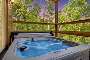 A hot tub with a wooden deck and a view of trees. - Hilltop Dreamin' 4 Bedroom Cabin by RedAwning (Sevierville)