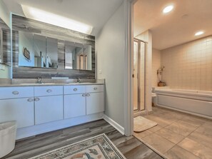 A modern bathroom with a large mirror, a sink with two basins, and a shower area. - Oceanview Condo In Brighton, 1504 - Full Access 2 Bedroom Condo (Myrtle Beach)