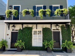 A two-story building with a balcony, a central window, and a door. - The Shain Manor Parlor Suite (Savannah)
