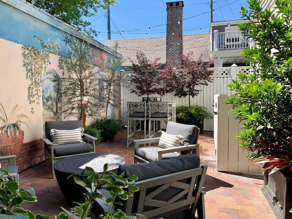 Un'area patio con mobili da esterno, un barbecue e un murale sulla parete.