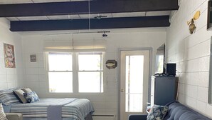 A room with a bed, a sofa, a desk, and a window.