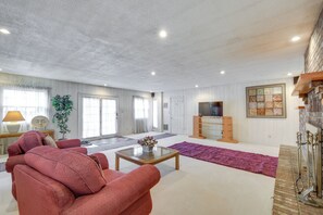 A spacious living room with a large sofa set, a coffee table, and a fireplace. - Spacious Studio - 5 Mi to MGM Northfield Park! (Maple Heights)