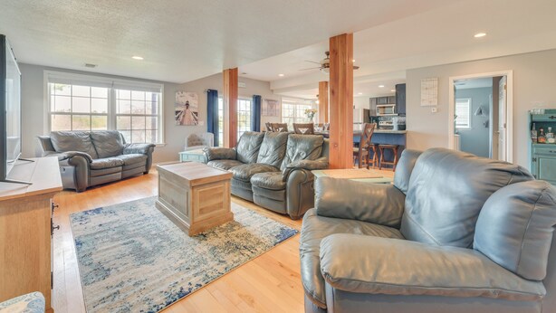 A spacious living room with leather sofas, a wooden coffee table, and a large rug. - Riverfront Cheboygan Home w/ Dock ~ 4 Mi to Town! (Cheboygan)
