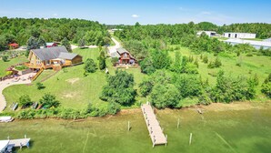 An aerial view of a property with a large house, a dock, and a forested area. - Riverfront Cheboygan Home w/ Dock ~ 4 Mi to Town! (Cheboygan)