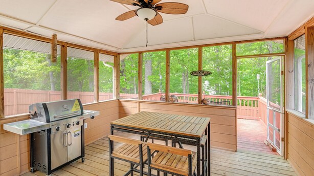 A covered outdoor area with a grill, table, and chairs, large windows, and a ceiling fan. - Cozy Hermitage Home w/ Deck: 11 Mi to Nashville! (Hermitage)