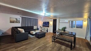A modern living room with a sofa, coffee table, and TV. - Stargaze Grand Canyon (Meadview)