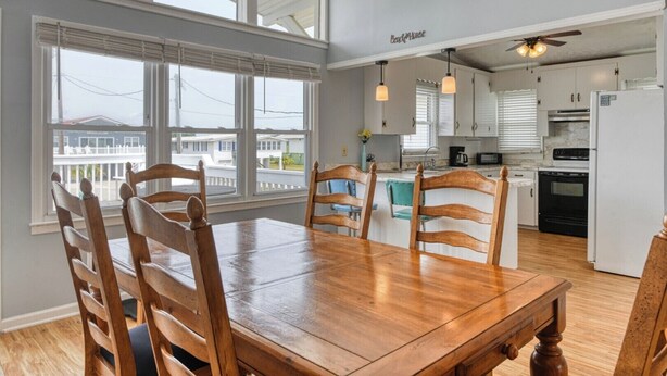 A spacious kitchen with a dining area, large windows, and a view of the outside.