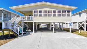 A two-story building with a covered walkway and a staircase leading to a deck.