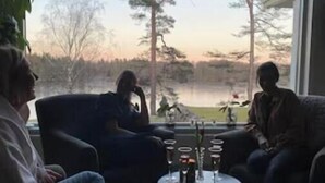 A room with a large window overlooking a lake and trees, two sofas, and a small table with glasses. - House with fantastic view and direct access to the lake and boat. (Skåne län)