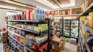 A grocery store with shelves stocked with various products including cleaning supplies, paper goods, and refrigerated items. - Villa CACA (Ksamil)