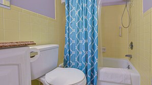 A bathroom with a toilet, a bathtub, and a shower curtain. - Directly on the Gulf - Unit  1 - 3 Bedroom - Ground Floor - Sleeps 6 (Venice)