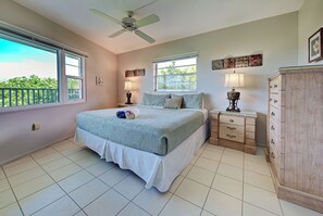 A bedroom with a bed, bedside tables, a dresser, a ceiling fan, and windows. - Directly on the Gulf - Unit  1 - 3 Bedroom - Ground Floor - Sleeps 6 (Venice)