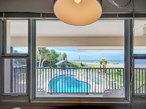 A view from a balcony with a pool, a beach, and a clear sky. - Directly on the Gulf - Unit 13 - 1 Bedroom - Second Floor - Sleeps up to 4 (Venice)