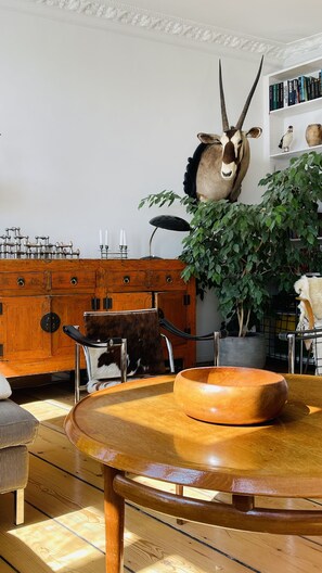 Cozy dining area with a round table, ornate cabinet, and vintage lamp.