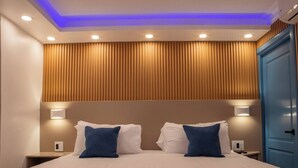 A hotel room with a bed, two bedside tables, a nightstand, a blue wardrobe, and a ceiling with recessed lighting. - Garden Condos 39, Luxury Apartment In Sosua Town! (Sosúa)