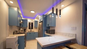A modern kitchen with blue cabinets, a marble island, and pendant lighting. - Garden Condos 39, Luxury Apartment In Sosua Town! (Sosúa)
