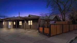 Un immeuble de deux étages avec un garage et une cour arrière clôturée.