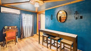 A room with a wooden table and chairs, a mirror on the wall, and an air conditioning unit. - The Bizarre and the Beautiful (Albuquerque)