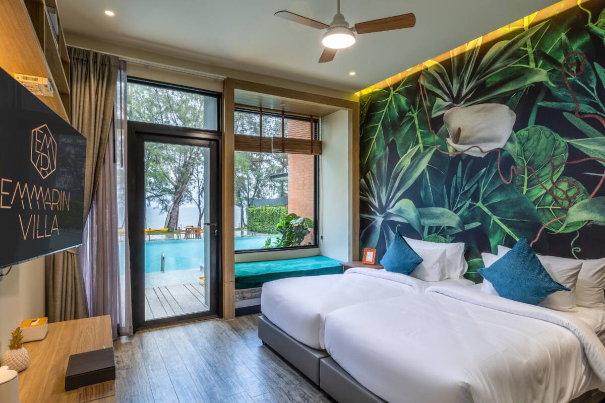 A modern hotel room with a large bed, a desk, and a view of a swimming pool.