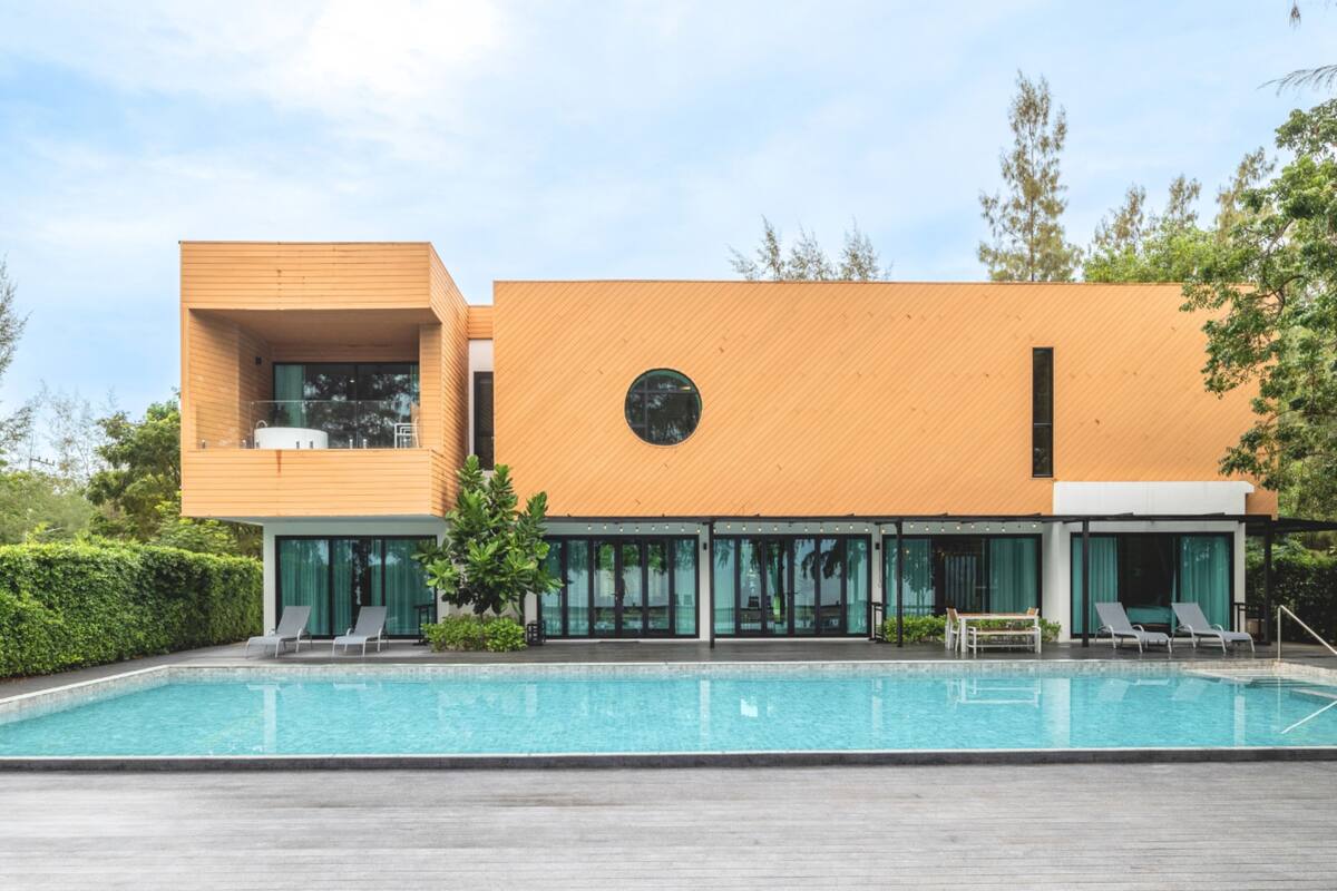 A modern building with a swimming pool, large windows, and a circular skylight.
