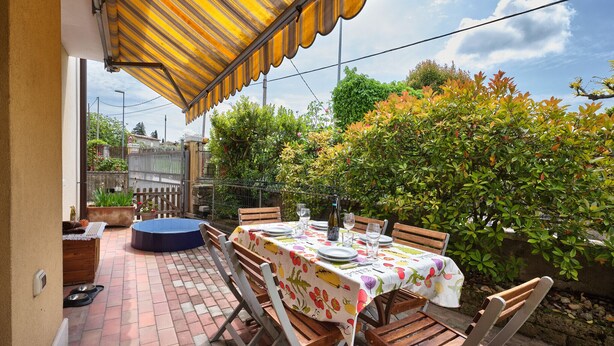 Eine Terrassengaststätte mit Esstisch, umgeben von Backsteinböden und Holzbänken.