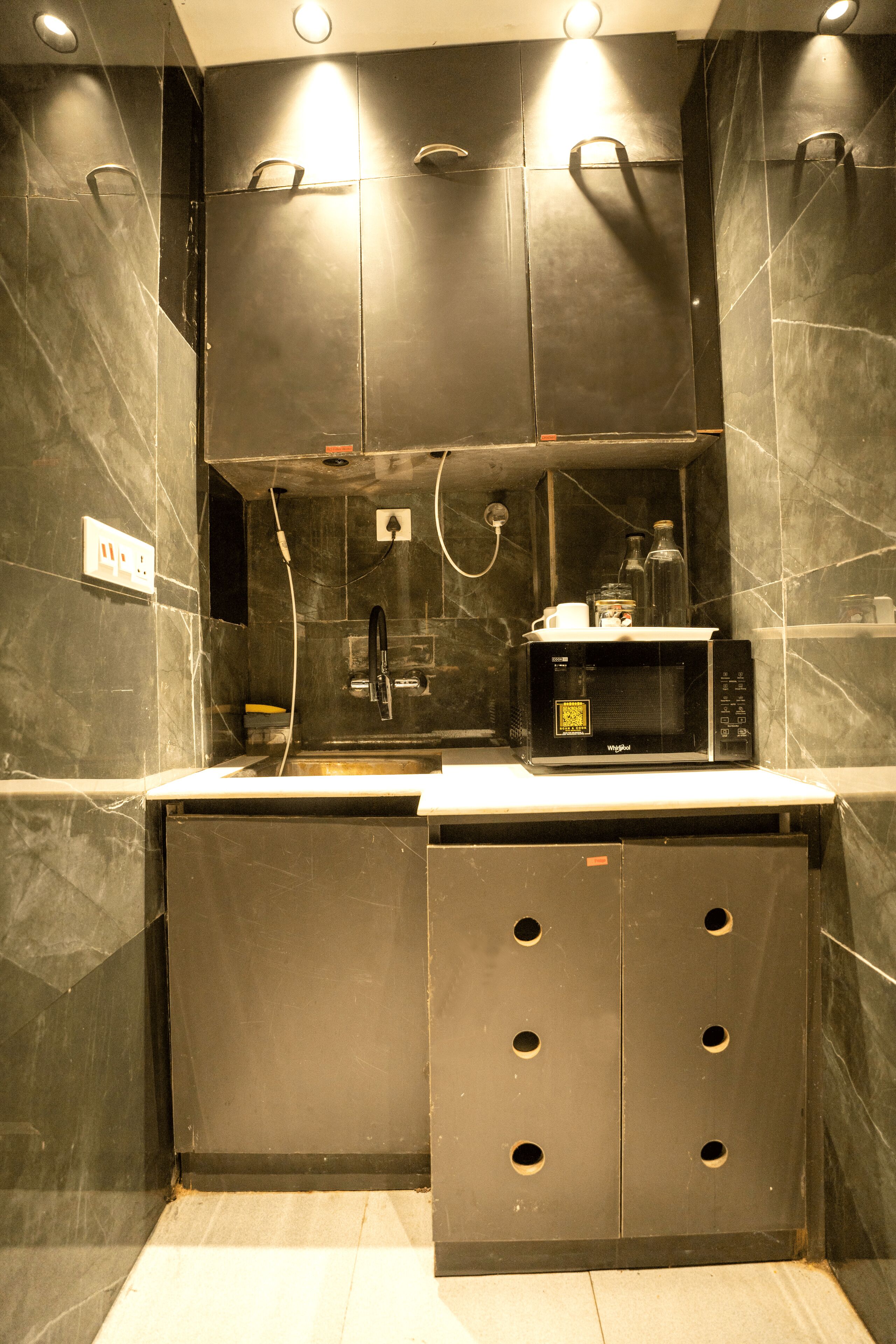 A compact kitchen with a microwave, a sink, and a small countertop.