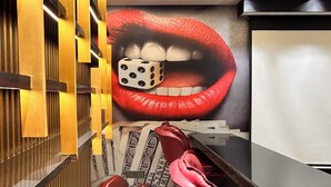 A modern interior with a large wall mural of red lips, a black desk, and a red chair. - Orsom Stays Sassy - Sector 42 (Gurugram)