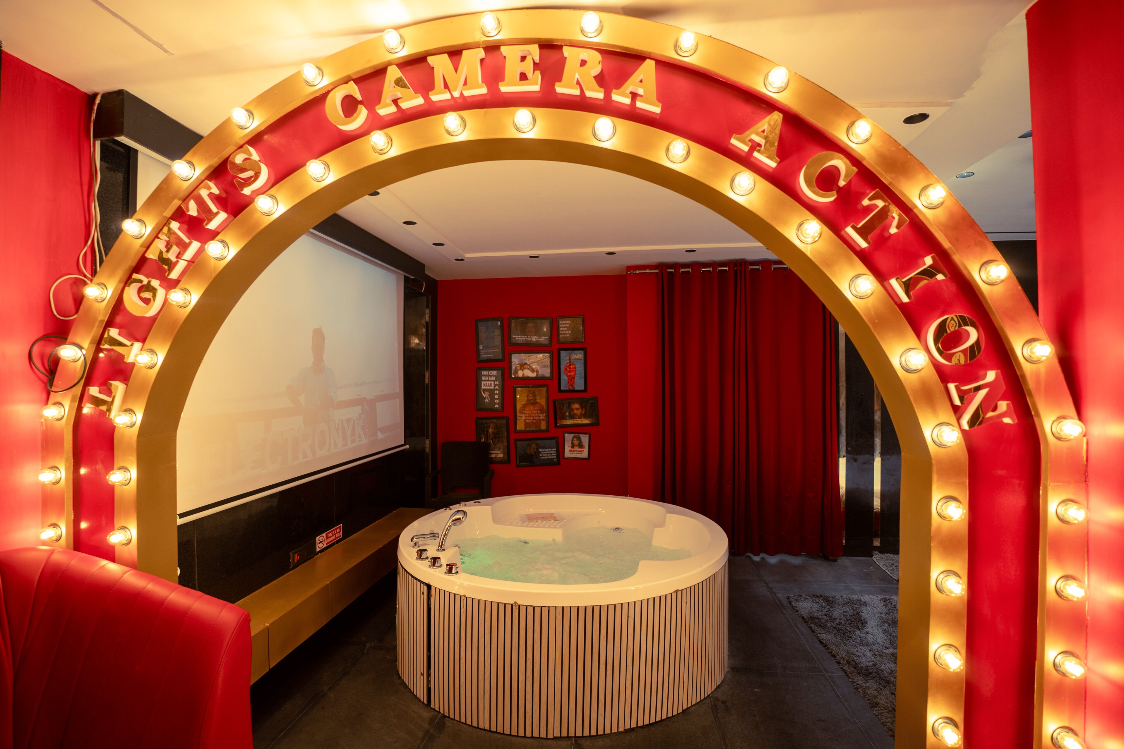 A red theater-themed room with a large screen, a circular seating area, and a sign reading "The Camera Action."