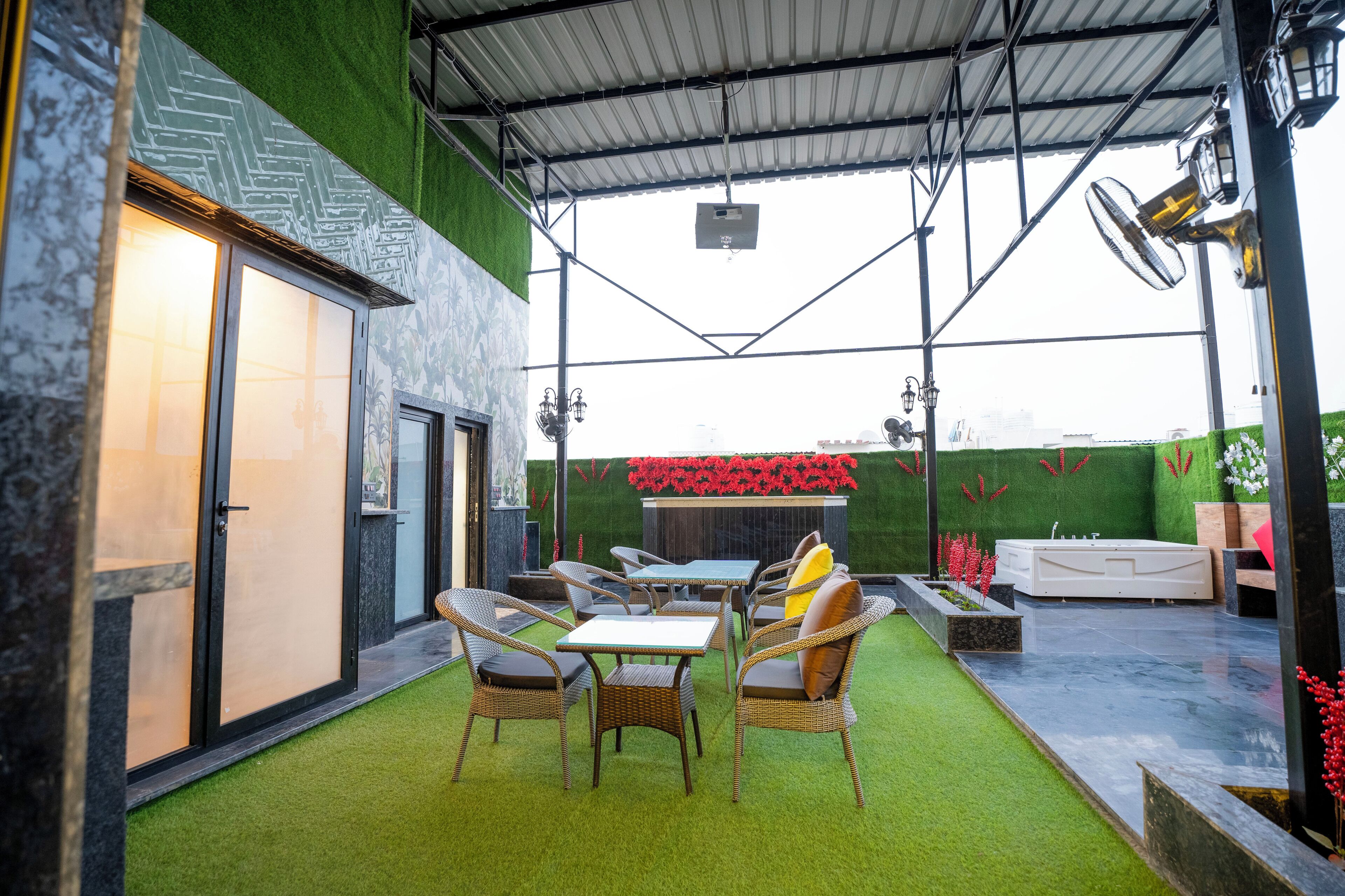 An outdoor patio with a dining table and chairs, a hot tub, and a fire pit.