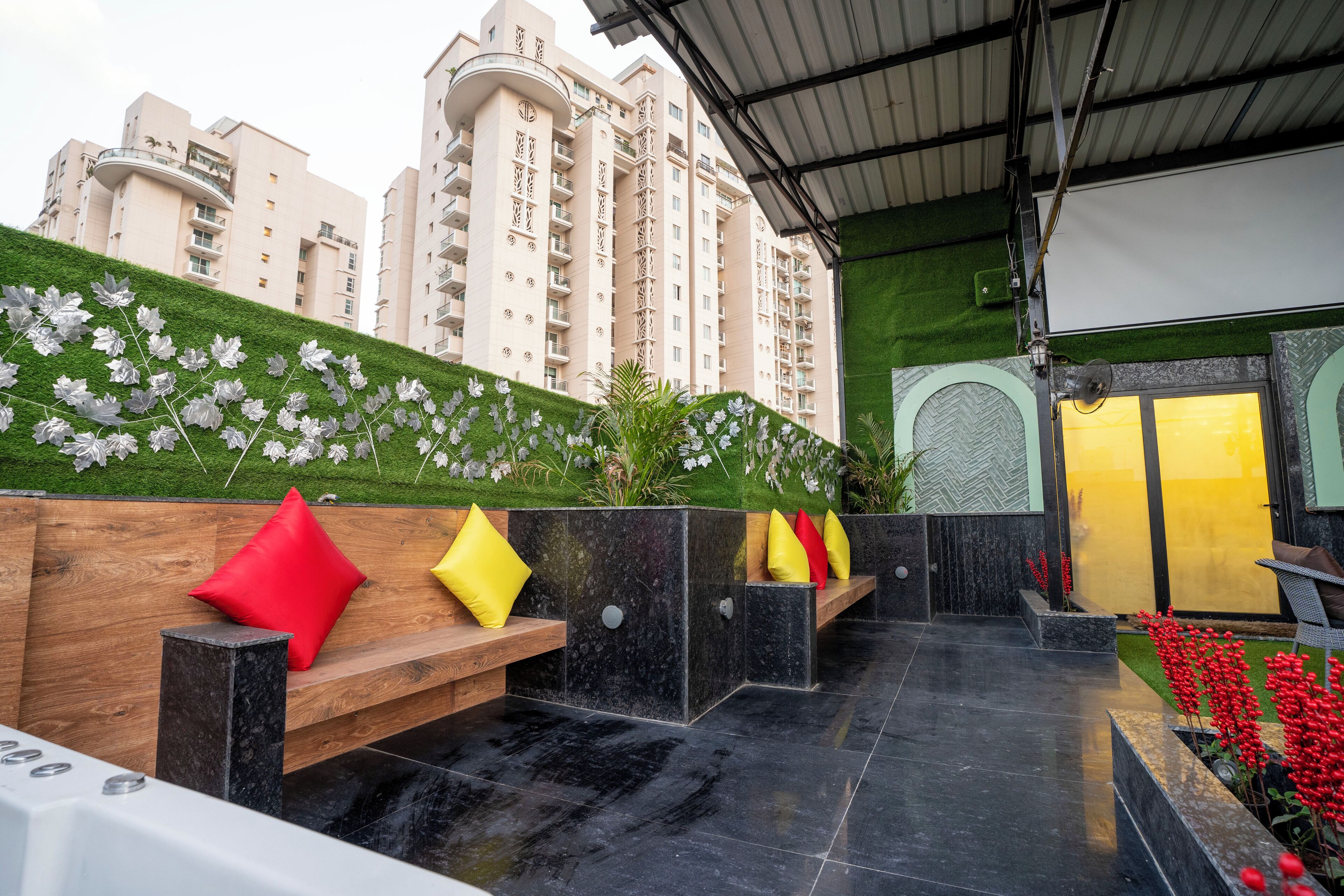 Un espacio al aire libre moderno con bancos y una pared decorativa.