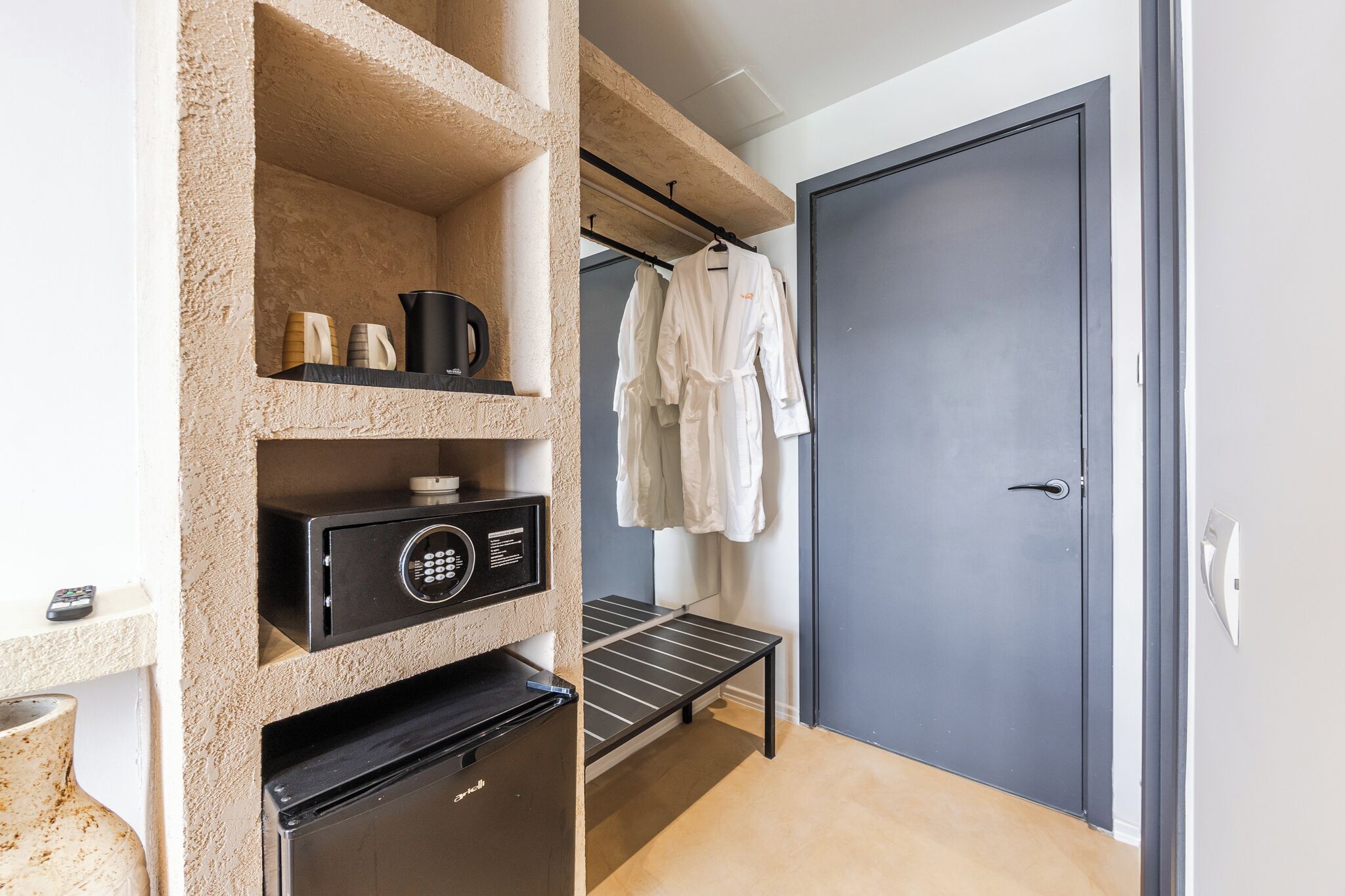 Una habitación compacta con kitchenette, un tendedero y una puerta con manija.